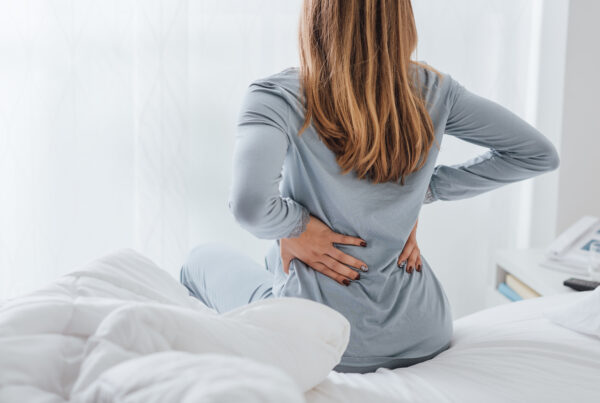 Woman waking up with lower back pain in the morning. Treatment with Sharp Physiotherapy in Bawtry, Lincoln and Newark.