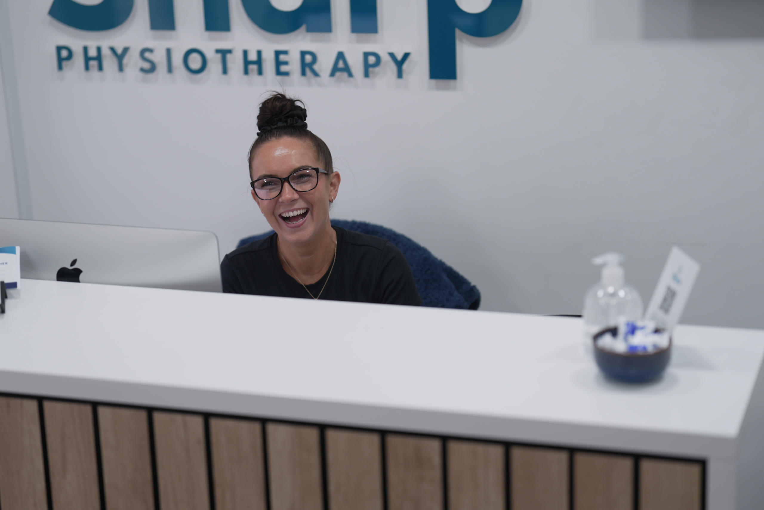 A friendly receptionist welcoming a patient at the front desk